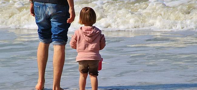 dziecko na plaży z rodzicem